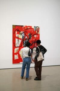 Hombre y mujer observando un cuadro rojo