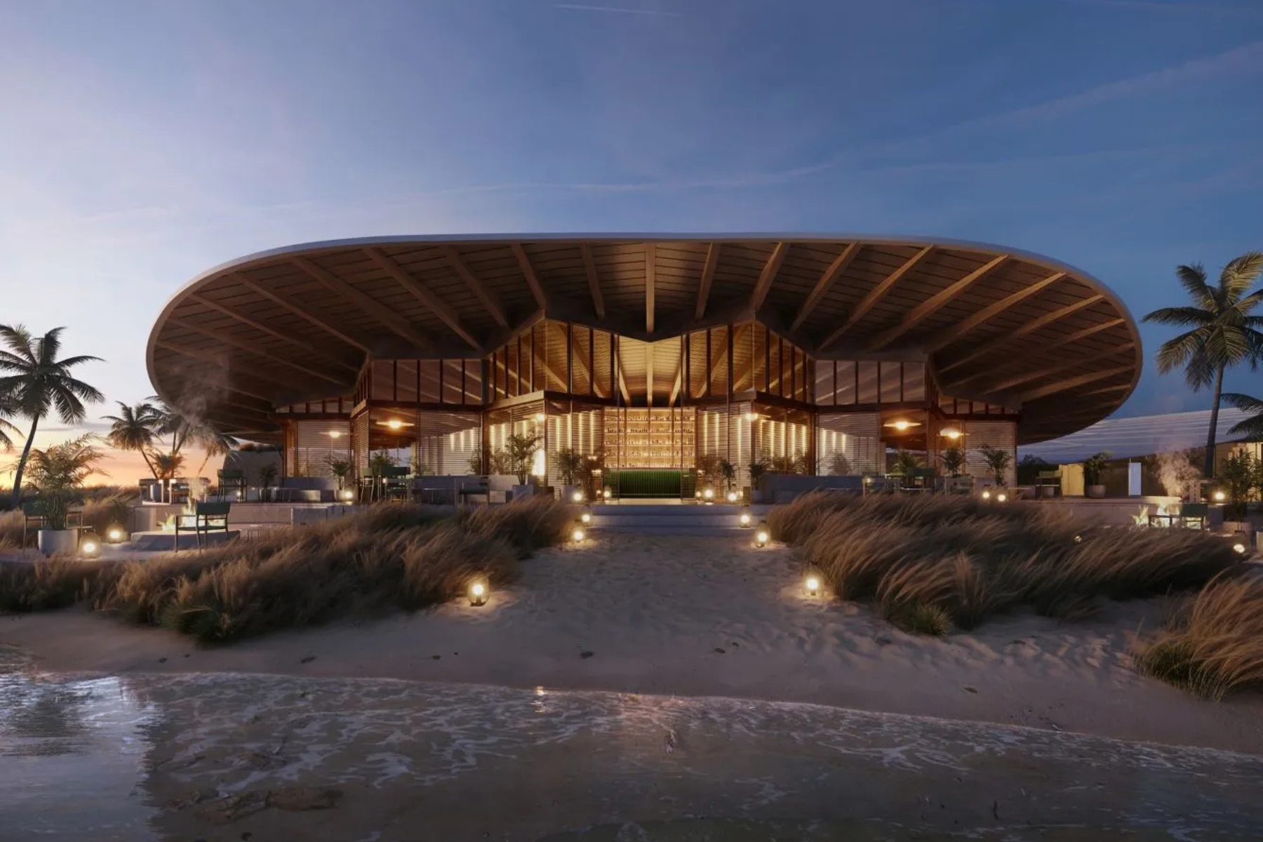 Modern beachfront pavilion with a curved circular roof, glass walls, and warm interior lighting at dusk on the sandy shore.
