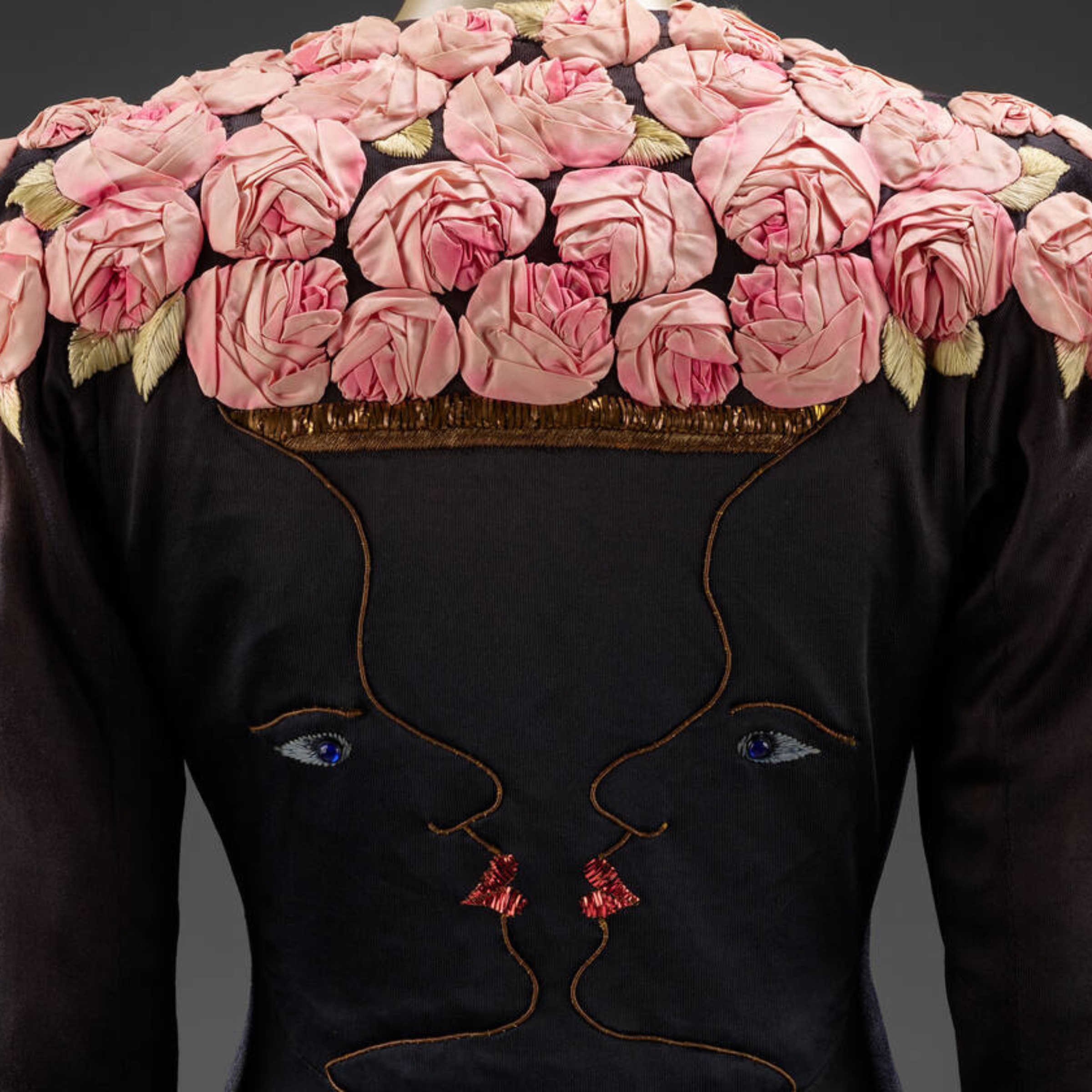 Dark dress bodice adorned with clustered pink rose embroidery and gold leaves.